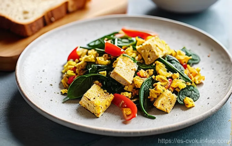 대체 단백질 요리법으로 만드는 아침식사 아이디어 - **Vibrant Tofu Scramble Breakfast:** A brightly lit, close-up shot of a steaming plate of savory tof...